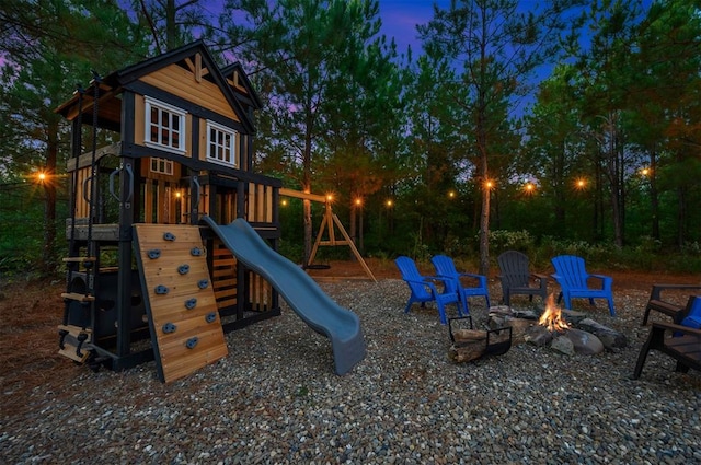 playground at dusk featuring a fire pit