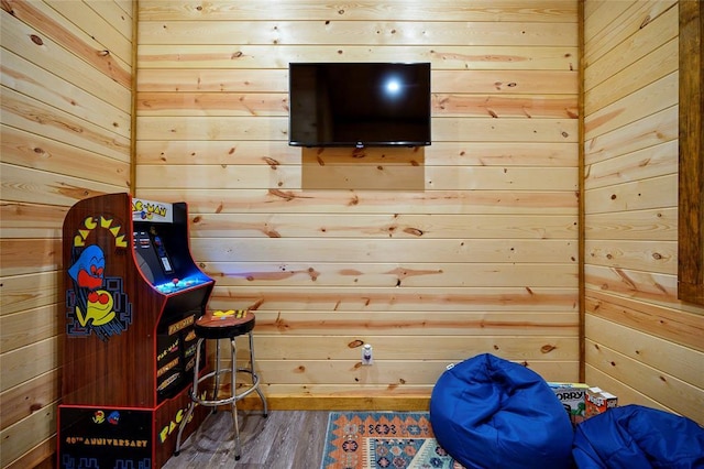 game room featuring hardwood / wood-style flooring and wooden walls