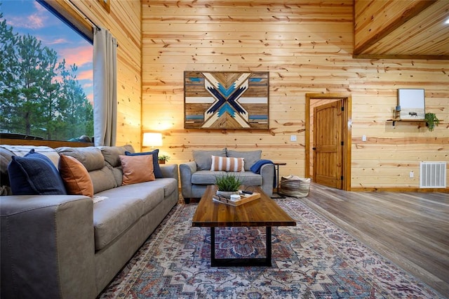 living room featuring hardwood / wood-style flooring, a wealth of natural light, and wood walls