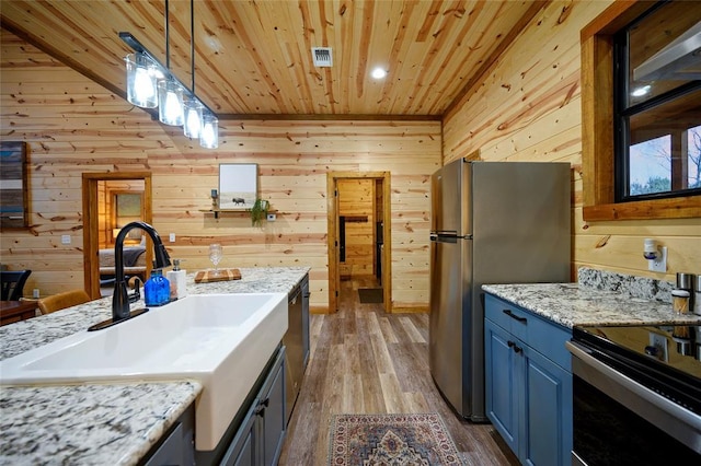 kitchen featuring light wood-type flooring, decorative light fixtures, wood ceiling, and wood walls