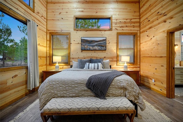 bedroom with wooden walls and wood-type flooring