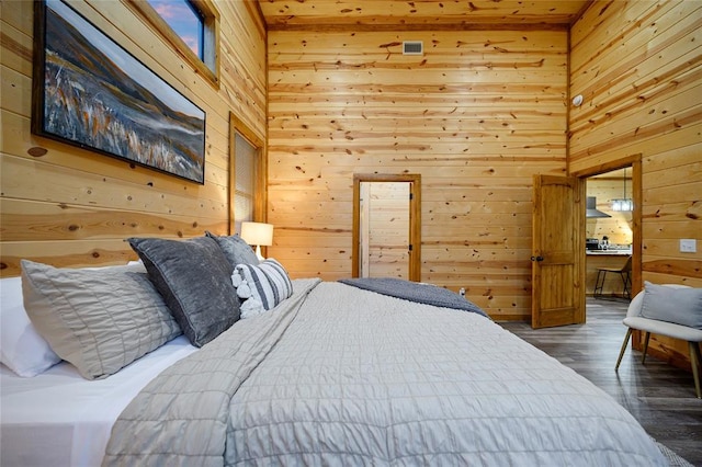 bedroom with dark hardwood / wood-style flooring and wooden walls