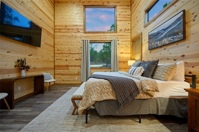 bedroom with wood walls and dark hardwood / wood-style flooring