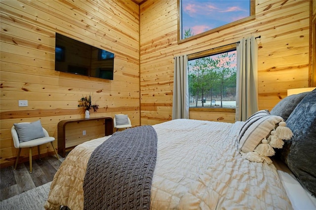 bedroom featuring hardwood / wood-style flooring and wooden walls