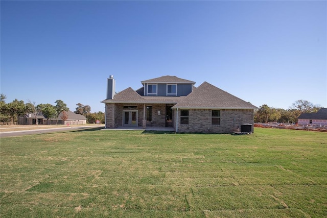 view of front of house with central air condition unit and a front yard