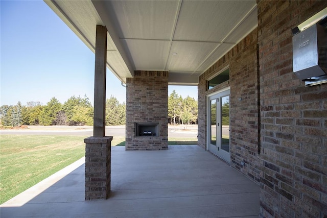 view of patio featuring french doors and an outdoor brick fireplace