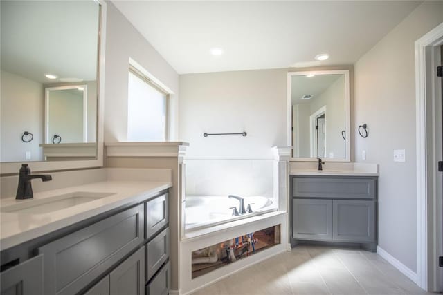 bathroom with tile patterned floors, vanity, and a tub to relax in