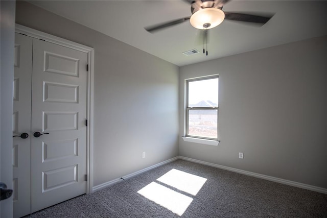 carpeted spare room featuring ceiling fan