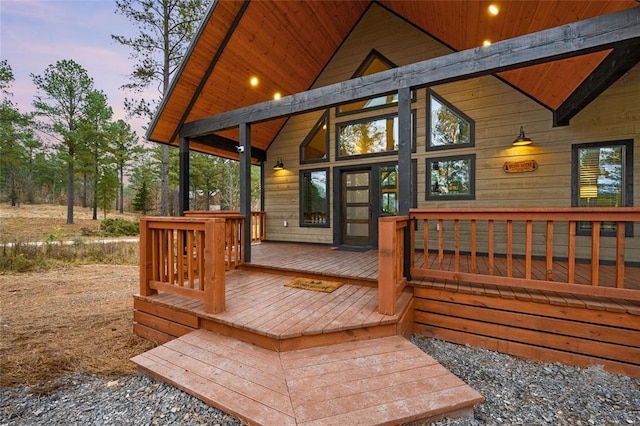 deck at dusk featuring a porch