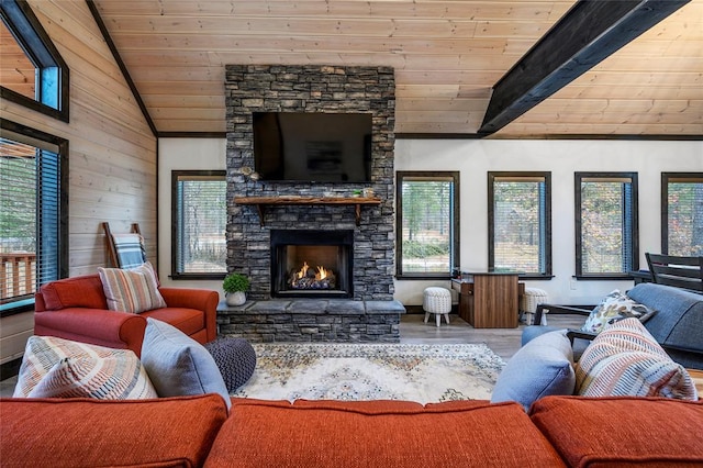 living room featuring a healthy amount of sunlight, a stone fireplace, wooden ceiling, and wood-type flooring