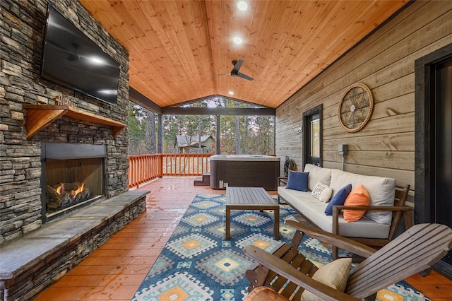 interior space with an outdoor stone fireplace, ceiling fan, lofted ceiling, and wood ceiling