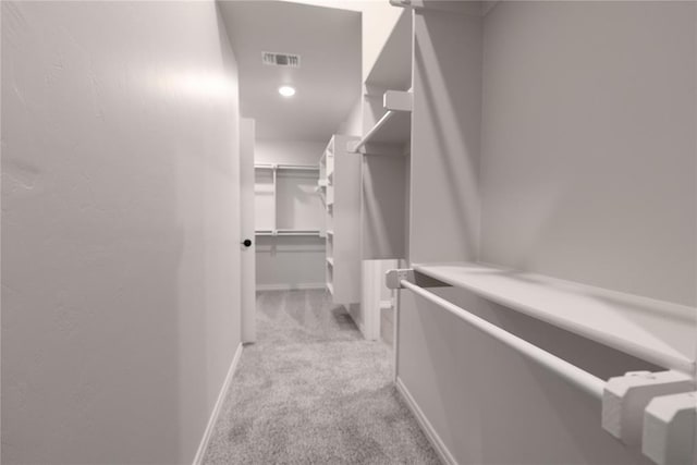 walk in closet featuring light colored carpet