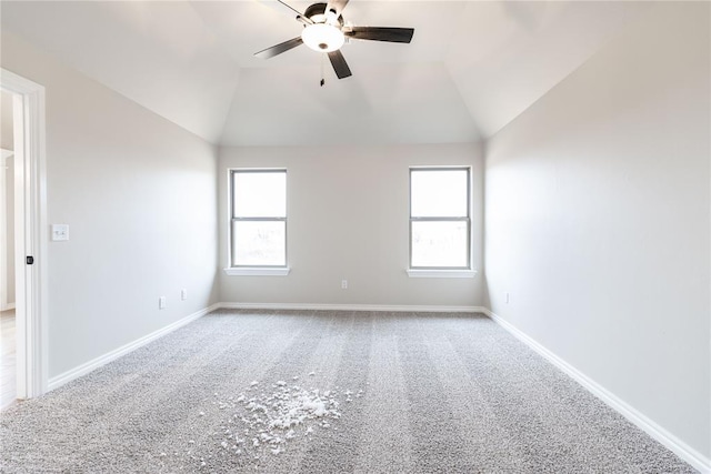 carpeted spare room featuring lofted ceiling, a wealth of natural light, and ceiling fan