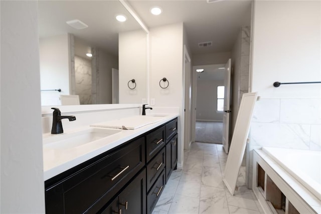 bathroom featuring vanity and a tub