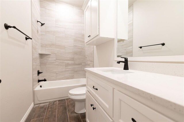 full bathroom featuring vanity, tiled shower / bath, and toilet