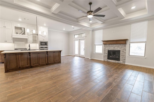 kitchen with ceiling fan, white cabinetry, hanging light fixtures, black microwave, and beamed ceiling