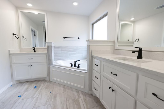 bathroom featuring vanity and a tub to relax in