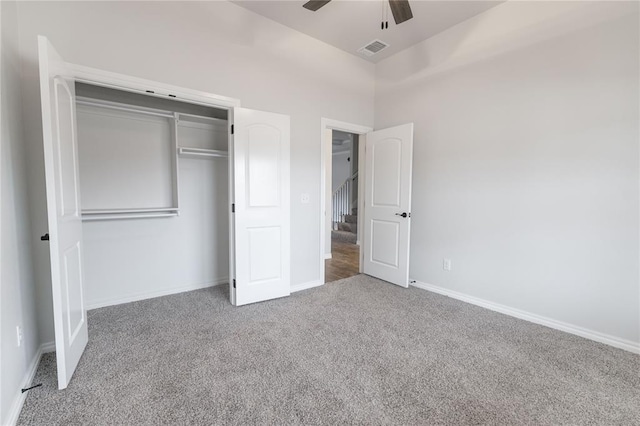 unfurnished bedroom featuring carpet floors, ceiling fan, and a closet