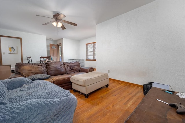 living room featuring wood-type flooring and ceiling fan