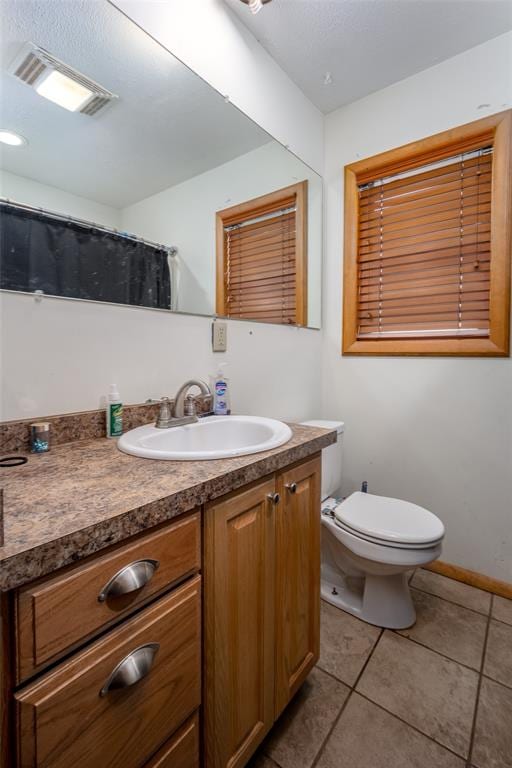 bathroom featuring tile patterned flooring, vanity, and toilet