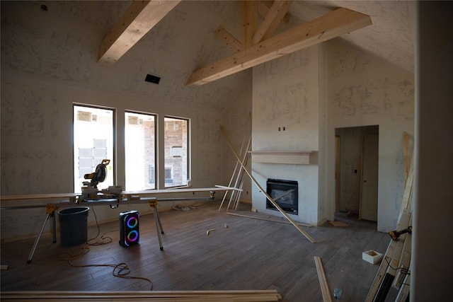 living room featuring beamed ceiling, wood-type flooring, and high vaulted ceiling