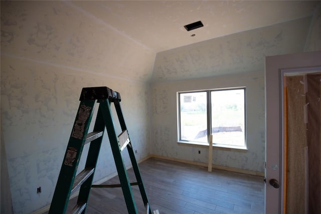 workout room featuring lofted ceiling and hardwood / wood-style flooring