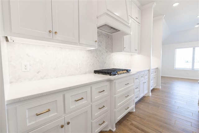 kitchen with tasteful backsplash, recessed lighting, stainless steel gas stovetop, light wood-style flooring, and white cabinetry