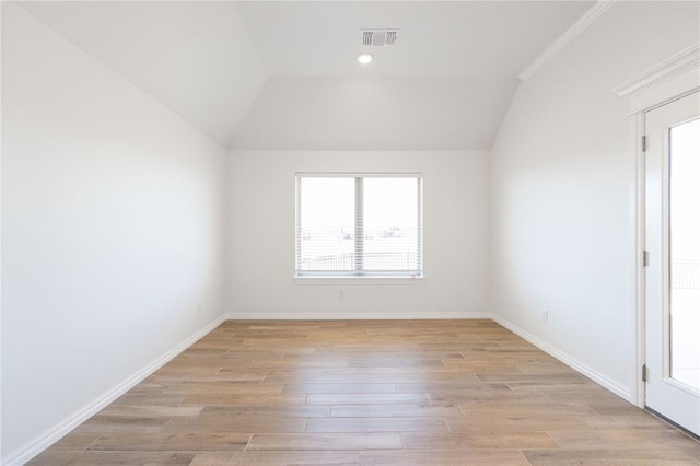 interior space featuring lofted ceiling, baseboards, visible vents, and light wood finished floors