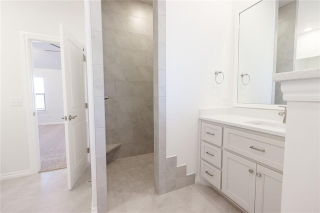 full bath with tile patterned flooring, baseboards, walk in shower, and vanity