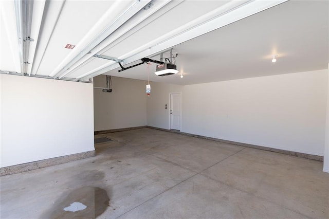 garage featuring a garage door opener and baseboards