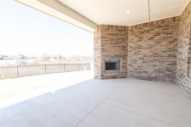 view of patio / terrace featuring an outdoor brick fireplace and a fenced backyard