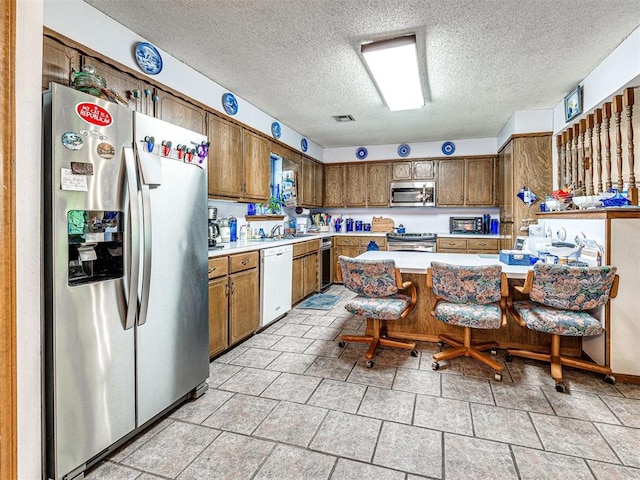 kitchen with a textured ceiling and stainless steel appliances