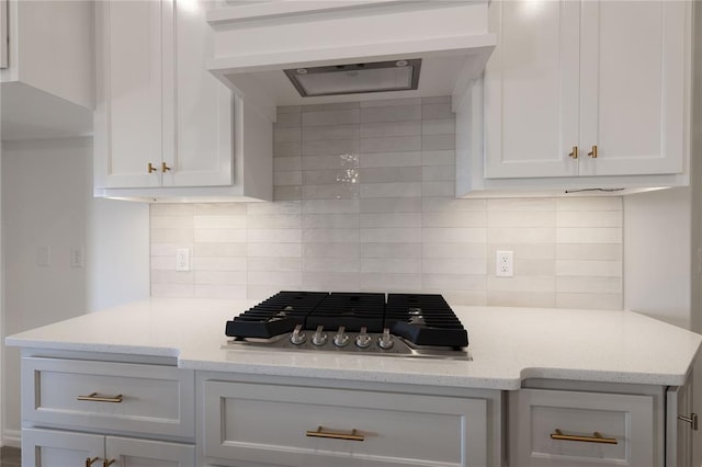 kitchen with white cabinets, decorative backsplash, and range hood