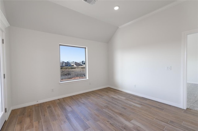 unfurnished room with vaulted ceiling, crown molding, and light hardwood / wood-style flooring