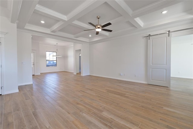 unfurnished living room featuring a barn door, coffered ceiling, and ornamental molding