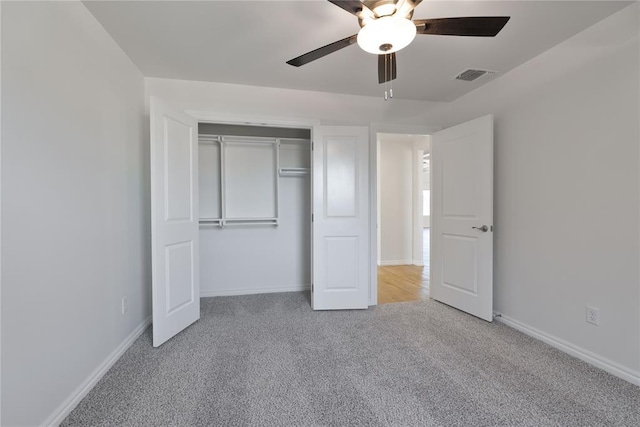 unfurnished bedroom featuring ceiling fan, a closet, and light carpet