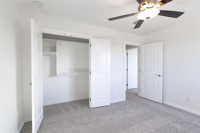 unfurnished bedroom featuring ceiling fan, a closet, and light colored carpet