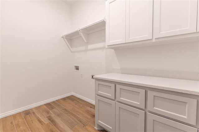 clothes washing area with light hardwood / wood-style floors, cabinets, and hookup for a washing machine