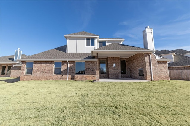 back of property with a lawn and a patio area