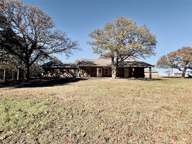 rear view of house featuring a yard