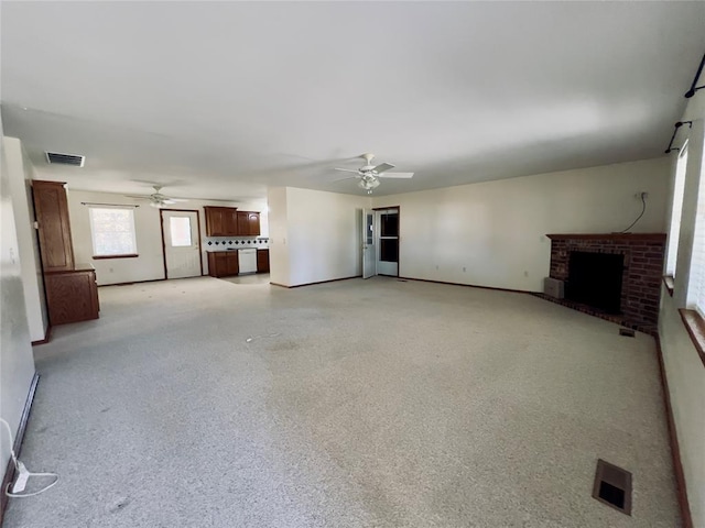 unfurnished living room with a brick fireplace and ceiling fan