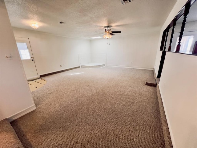 unfurnished room featuring ceiling fan, carpet, and a textured ceiling