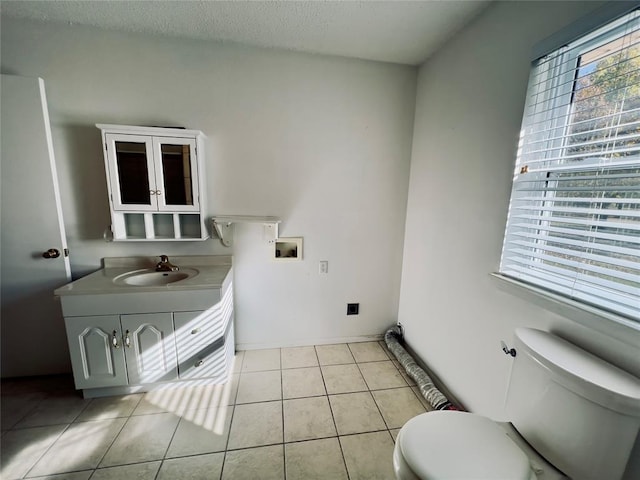 bathroom with tile patterned floors, vanity, toilet, and a textured ceiling