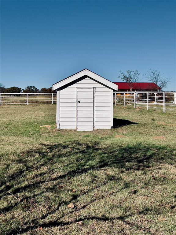 view of outdoor structure with a yard and a rural view