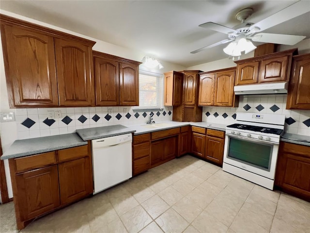 kitchen featuring decorative backsplash, white appliances, ceiling fan, and sink