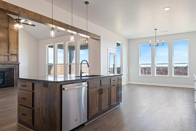 kitchen with dark hardwood / wood-style flooring, ceiling fan with notable chandelier, a center island with sink, dishwasher, and hanging light fixtures