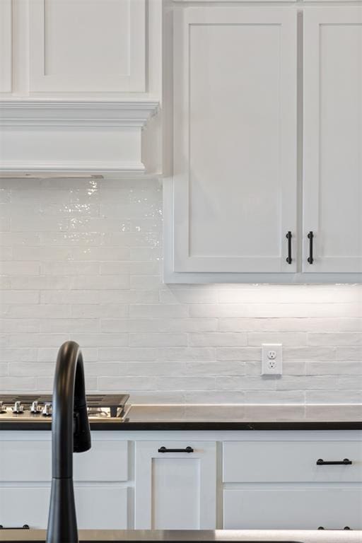 details with decorative backsplash and white cabinetry