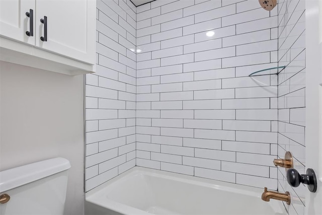 bathroom featuring toilet and tiled shower / bath