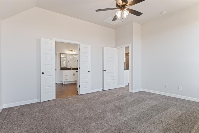 unfurnished bedroom featuring ensuite bathroom, dark carpet, ceiling fan, and lofted ceiling