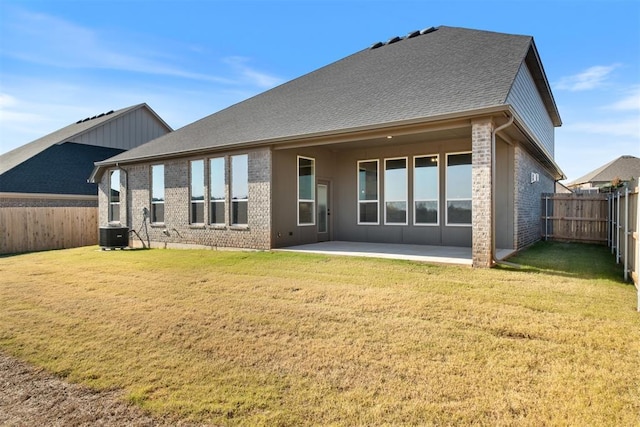 back of house with a lawn, a patio area, and central AC